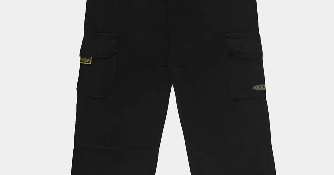 Pantalon cargo noir DDP porté avec des sneakers, base de la tenue année 90 homme
