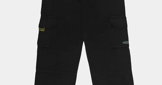 Pantalon cargo noir DDP porté avec des sneakers, base de la tenue année 90 homme